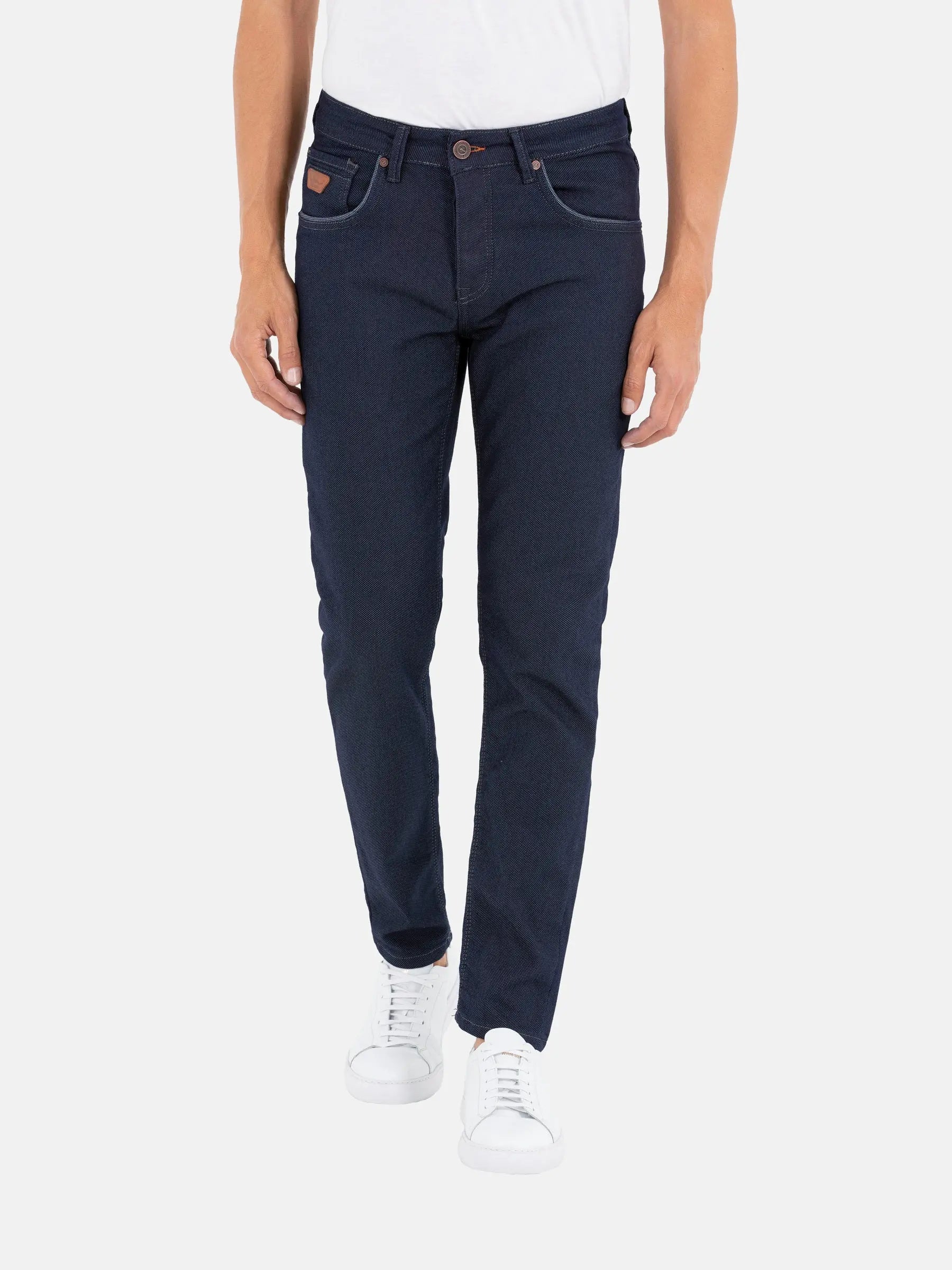 Men’s slim-fit dark blue jeans paired with white sneakers – Wam Denim.