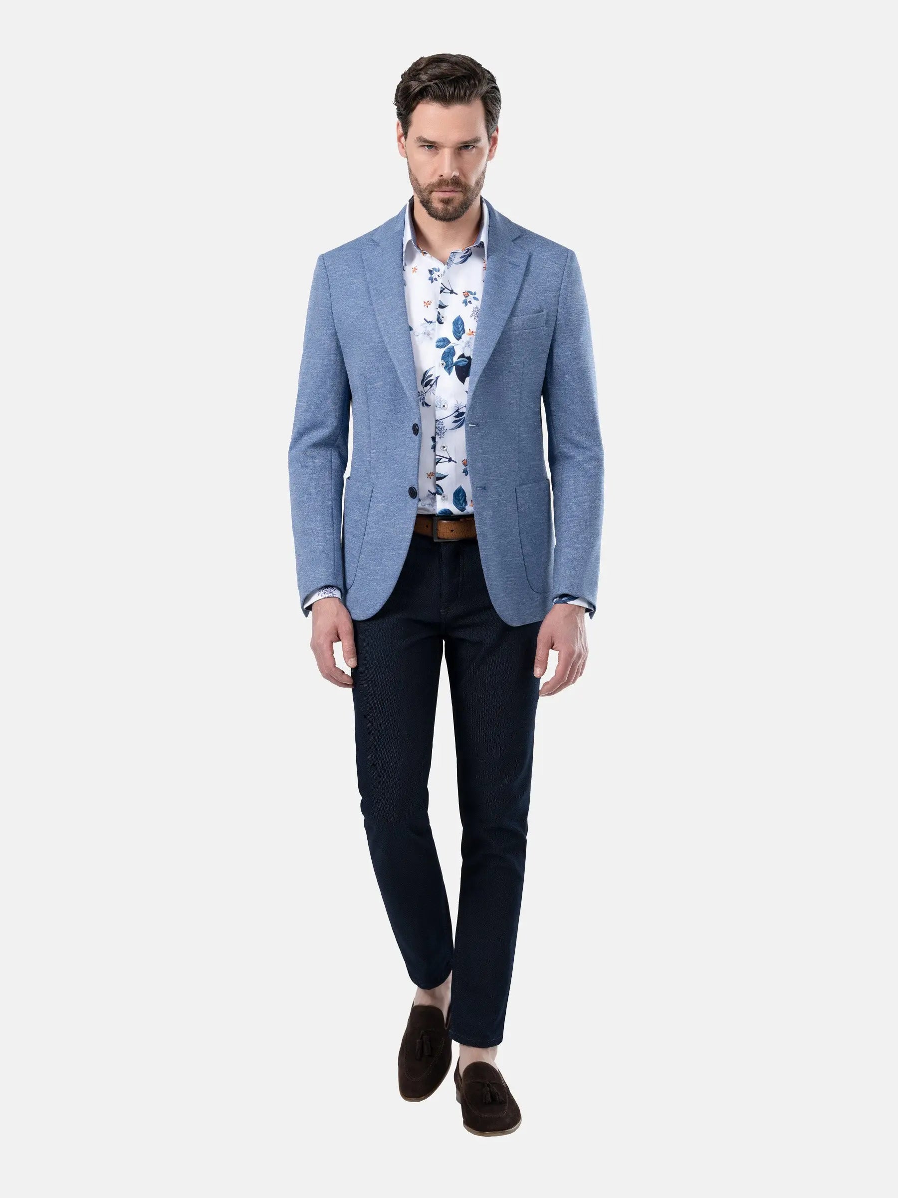 Model wearing light blue blazer with floral shirt and dark jeans, smart-casual look – Wam Denim.