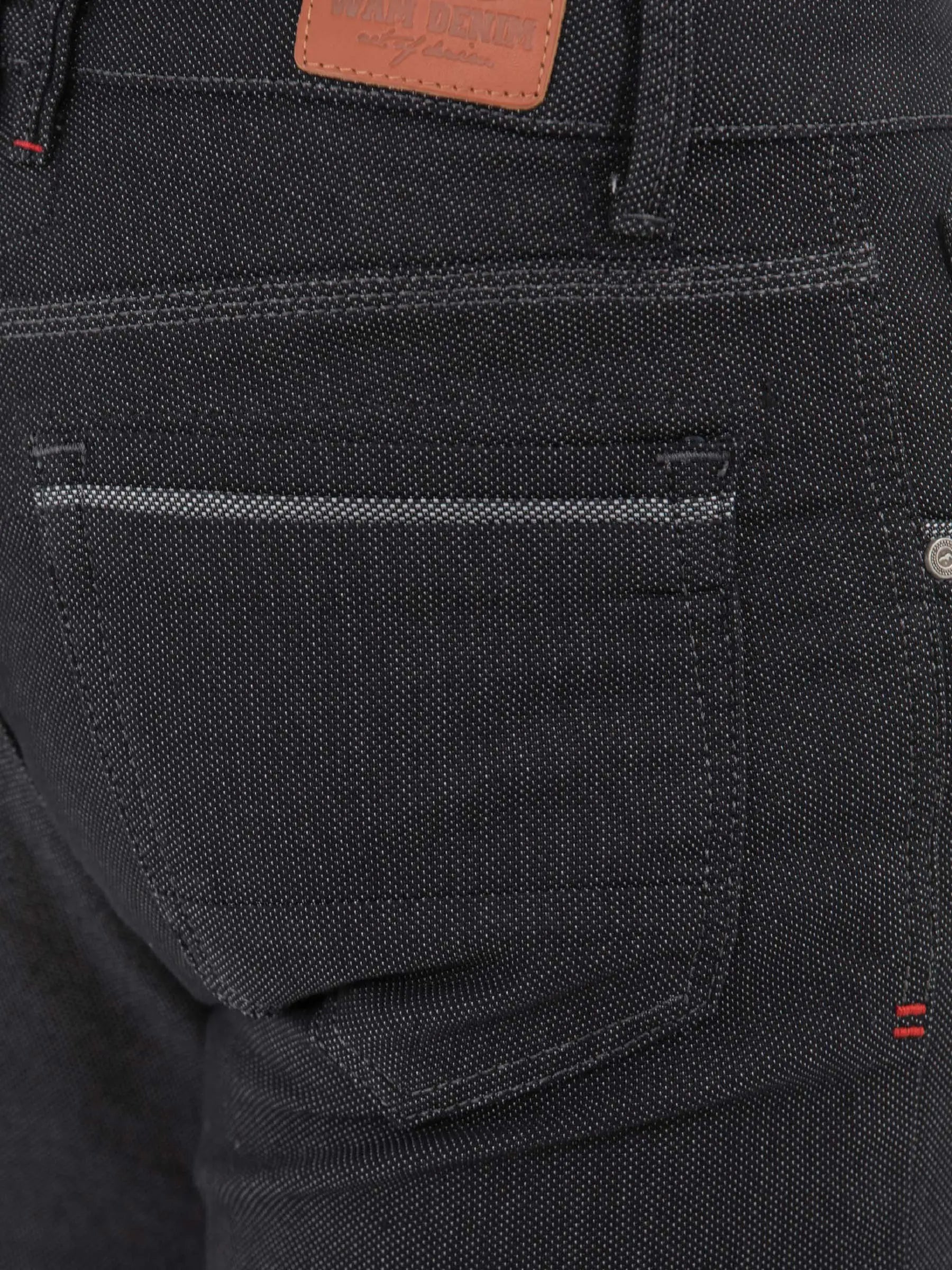 Close-up of black textured jeans back pocket with stitching and leather Wam Denim label – Wam Denim.