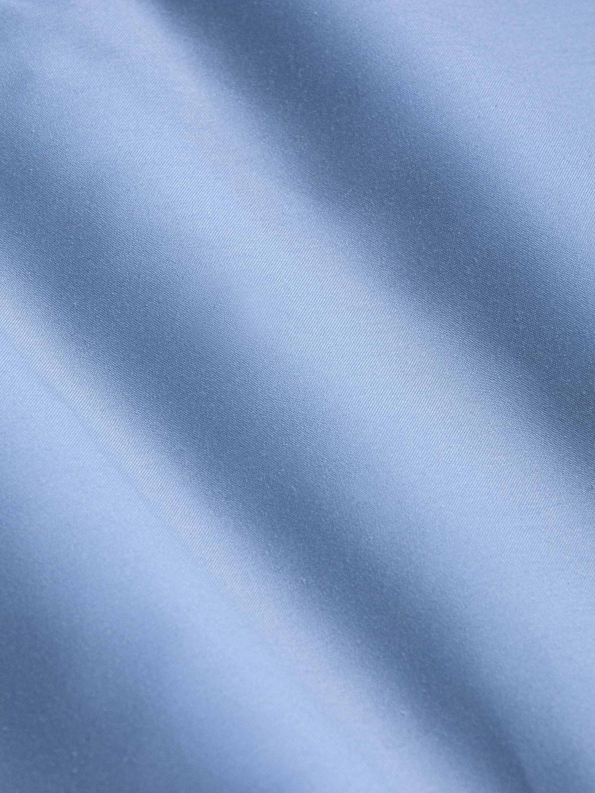 Close-up of smooth light blue fabric showing soft texture and fine weave – Wam Denim.