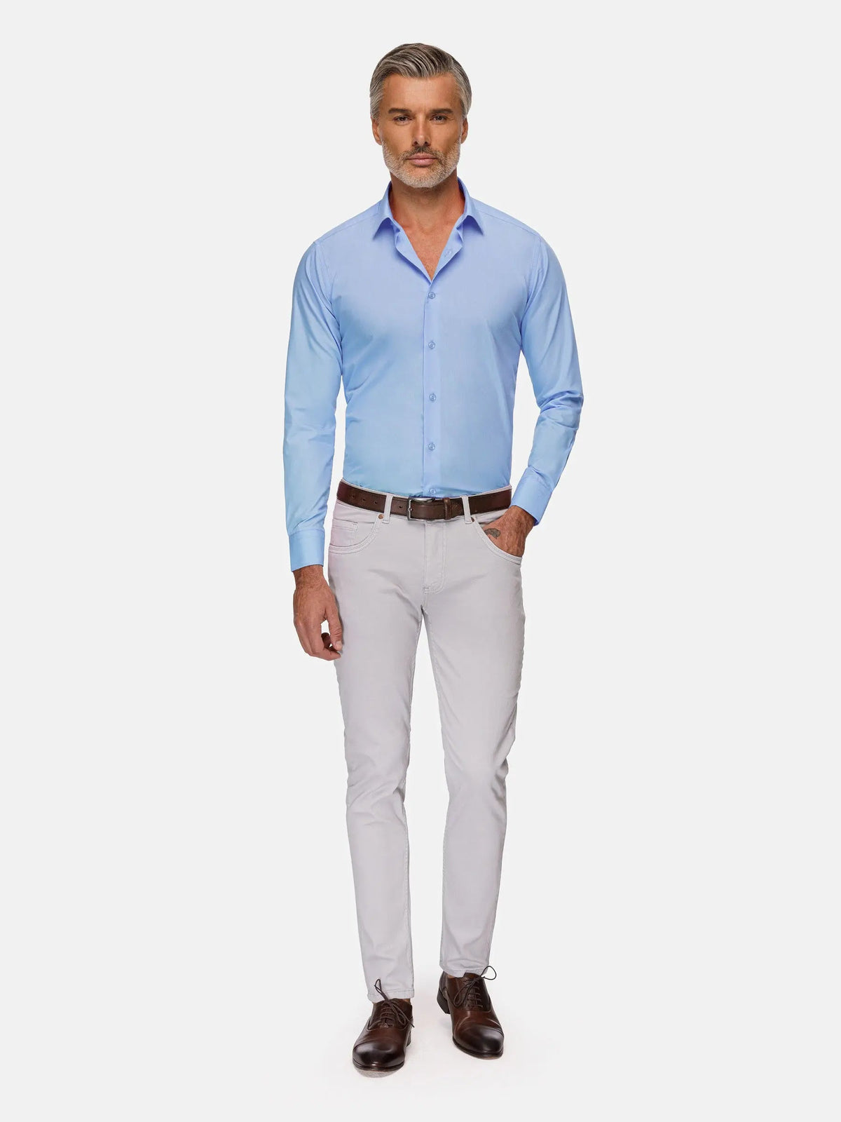 Full-body view of man wearing light blue slim-fit dress shirt with white pants and brown shoes – Wam Denim.