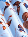 Close-up of light blue floral fabric with brown and navy leaf patterns – Wam Denim.