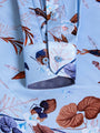 Close-up of floral cuff detail on light blue patterned shirt with buttoned sleeve – Wam Denim.