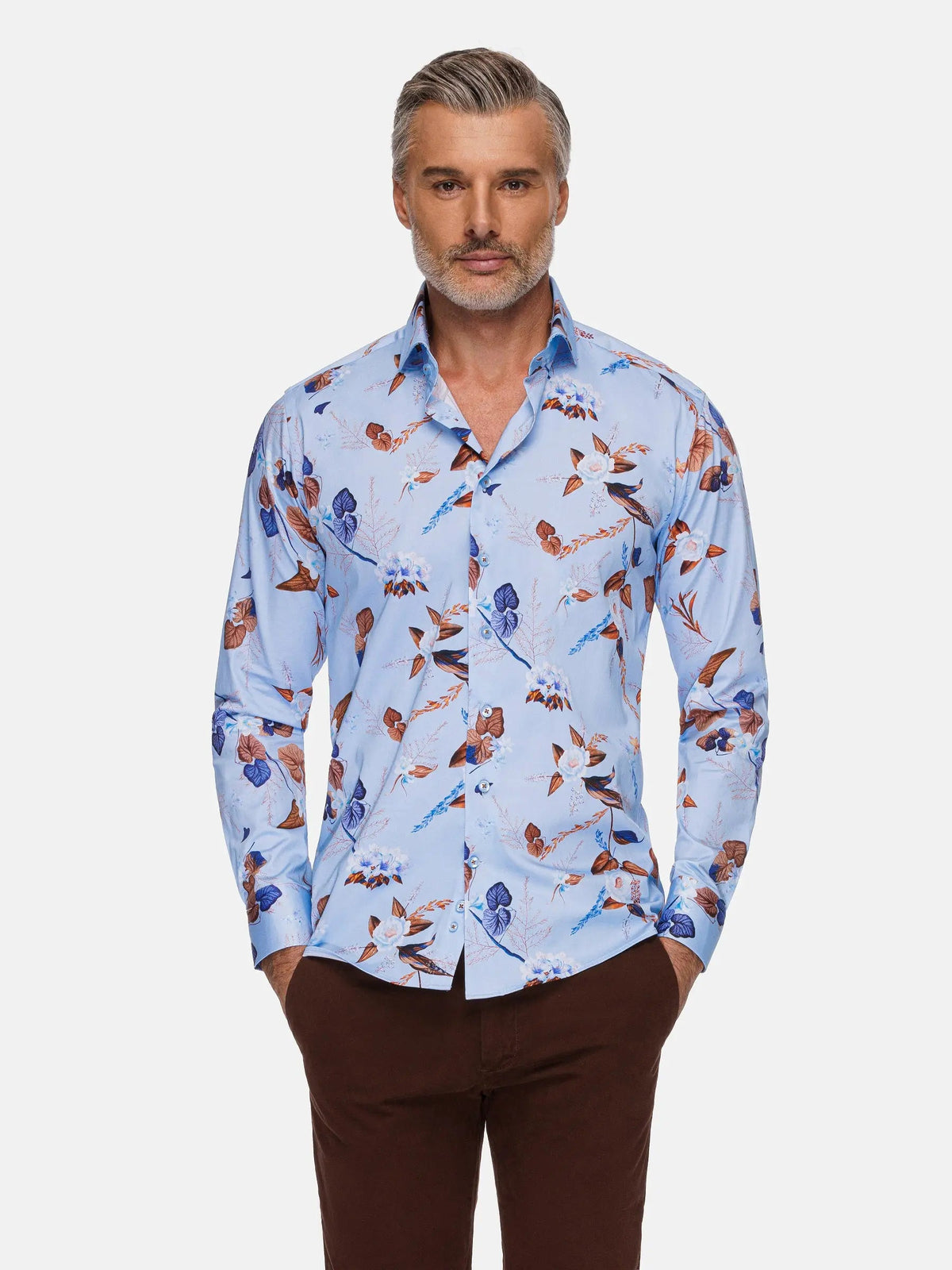 Man wearing a light blue floral print shirt paired with brown trousers – Wam Denim.