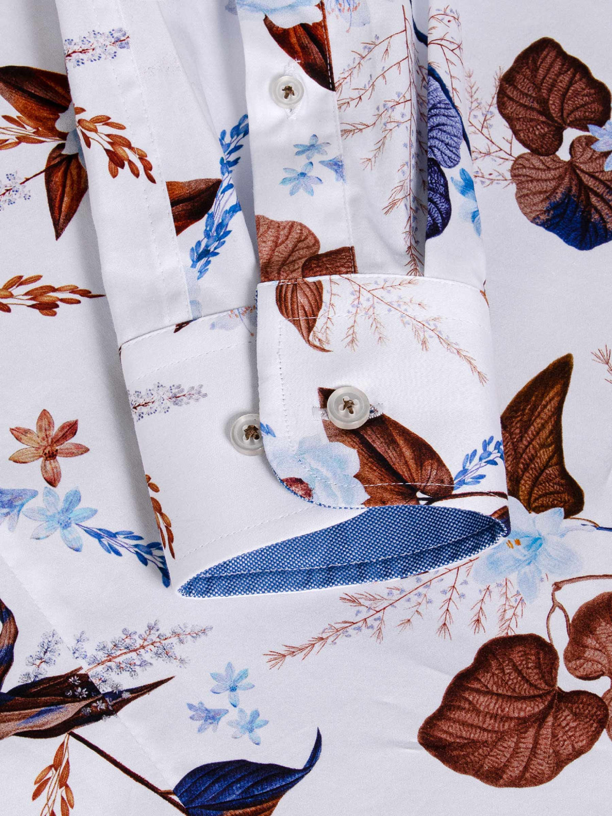 Close-up of floral shirt cuff with blue contrast inner lining and button detail – Wam Denim.