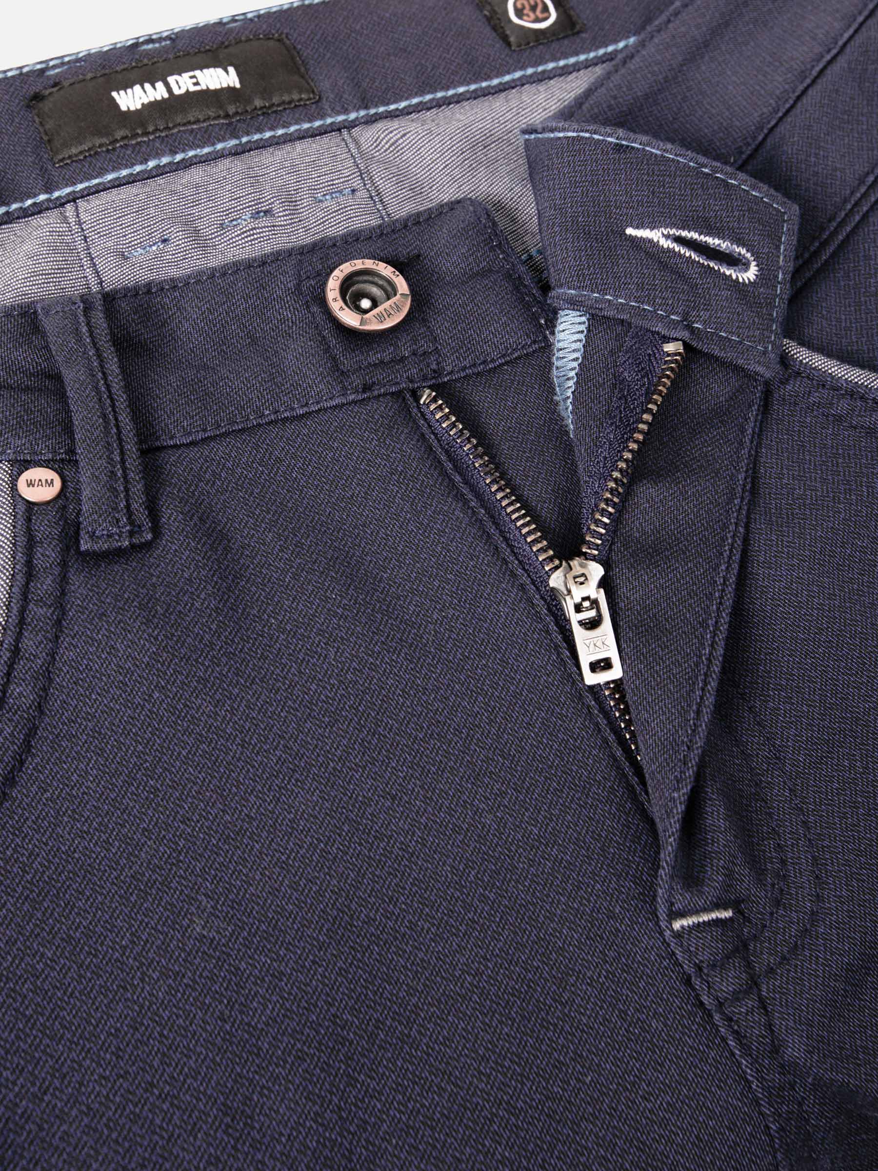 Close-up of dark blue jeans waistband with branded label. – Wam Denim.