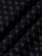 Close-up of black fabric with stitched geometric logo pattern and soft texture – Wam Denim.