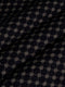 Close-up of black fabric with beige geometric pattern showing soft textured weave – Wam Denim.