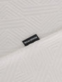 Close-up of the Wam Denim label on the textured white polo – Wam Denim.