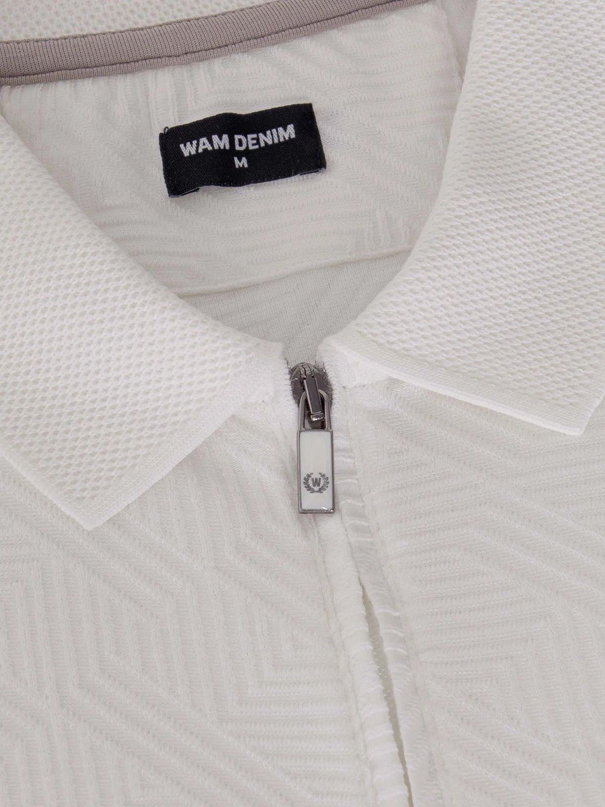 Close-up of the zipper and collar on the white zip polo shirt – Wam Denim.