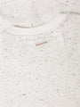 Speckled white sweater with a brand label on a white background