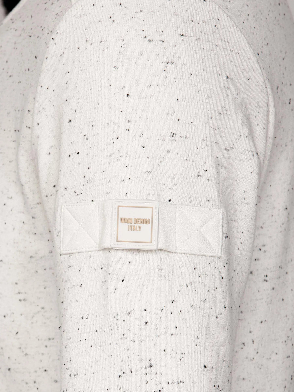 Speckled Off White sweater with a brand label on a matching background