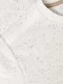 Close-up of a textured white fabric with black specks