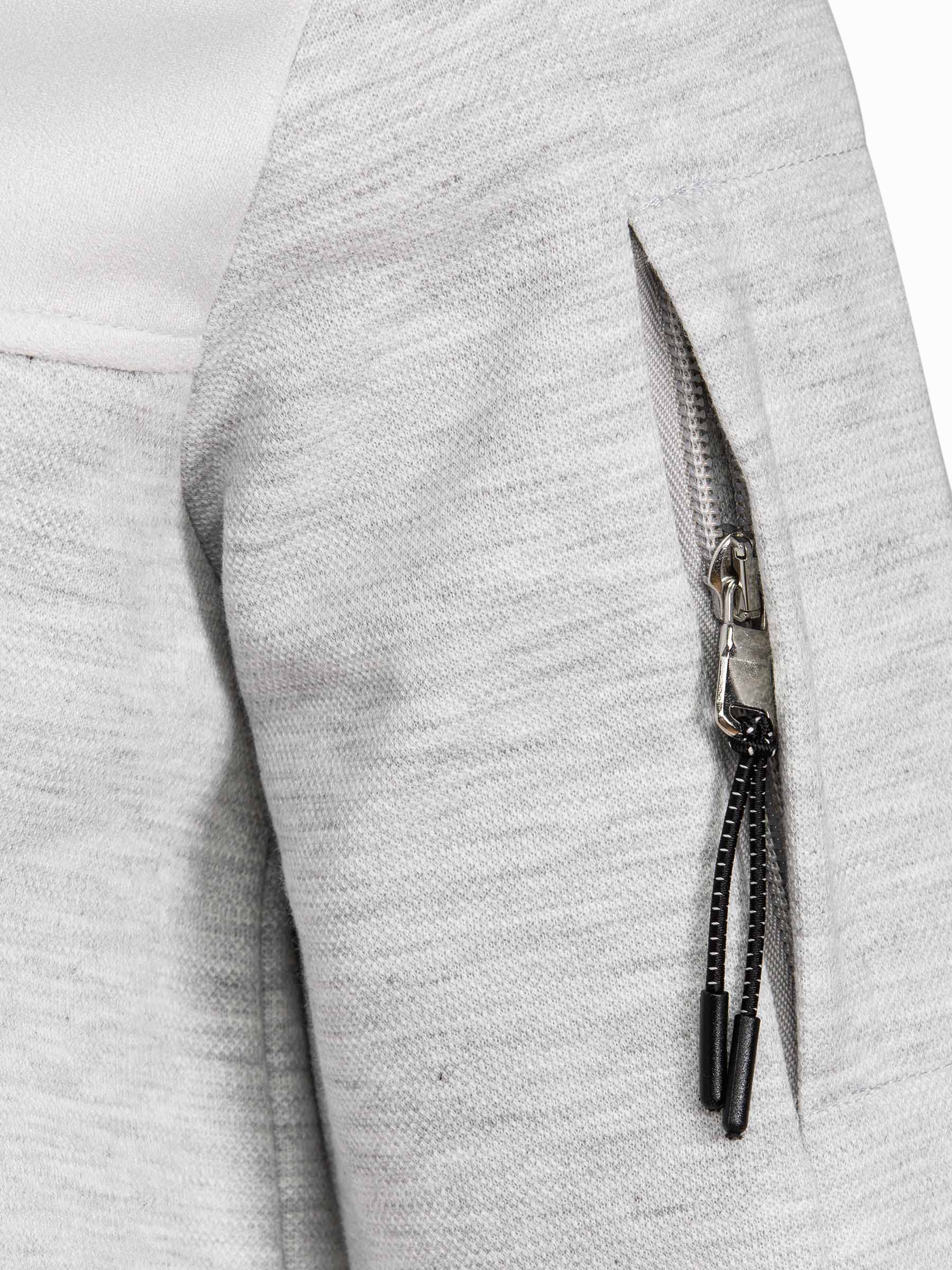 Close-up of sleeve zipper pocket detail on light grey sweatshirt fabric – Wam Denim.