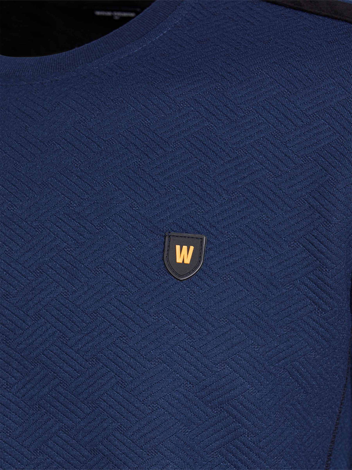 Close-up of navy Moorland Sweater with logo detail. – Wam Denim.
