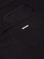 Close-up of black textured sweater fabric with Wam Denim logo tag on the back – Wam Denim.