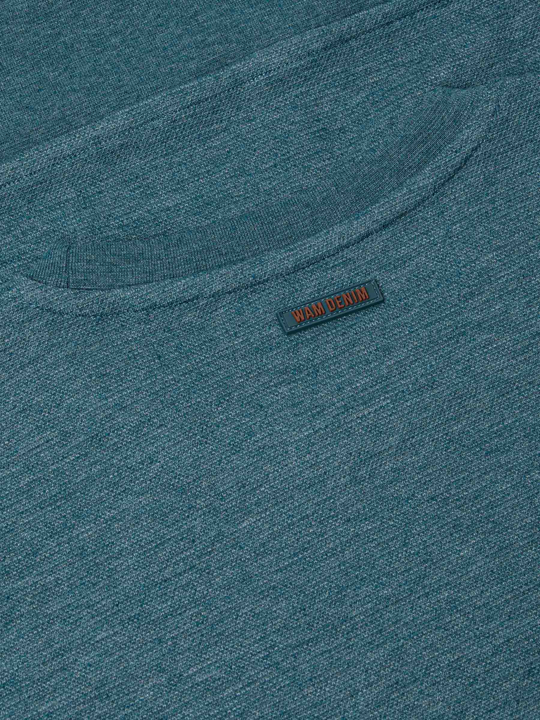 Close-up of back neck area with subtle Wam Denim logo tag on petrol fabric – Wam Denim.