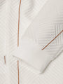 Close-up of white textured sweatshirt sleeve with brown stitching and cuff detail – Wam Denim.