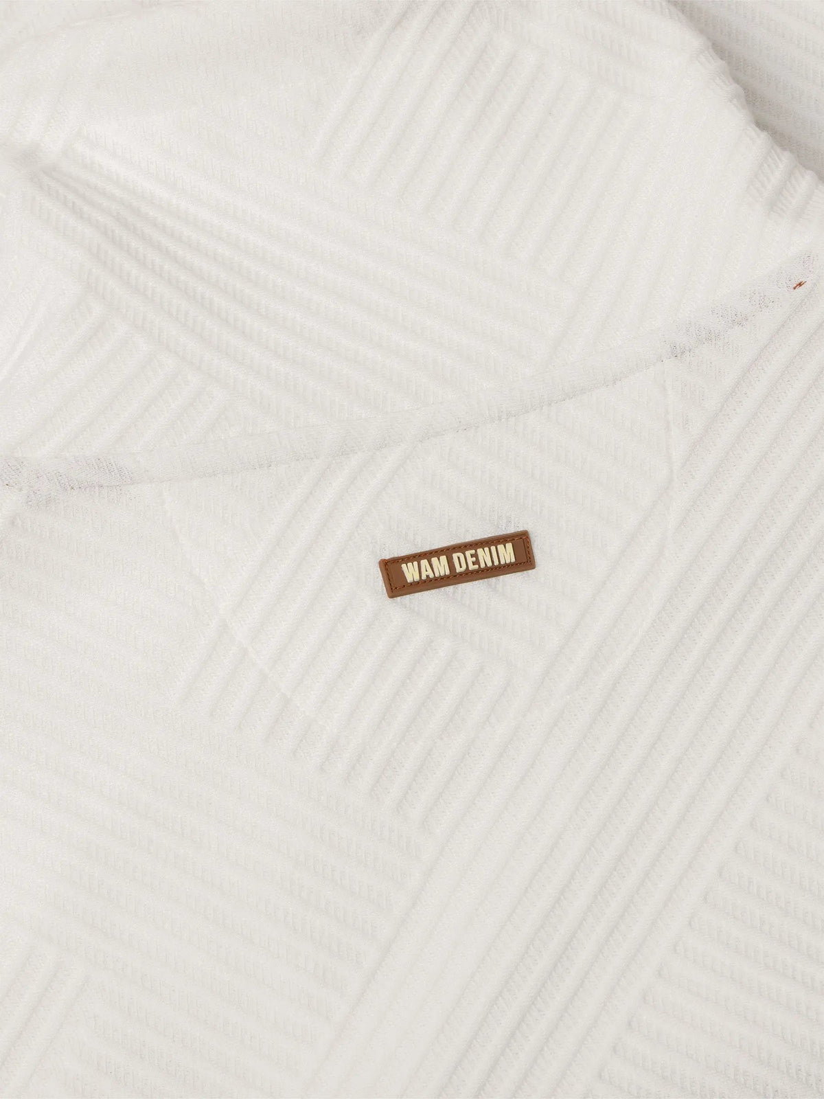 Close-up of white textured sweatshirt fabric with stitched Wam Denim logo patch – Wam Denim.