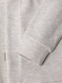 Close-up of light grey waffle-textured sweatshirt sleeve and hem with logo tag – Wam Denim.