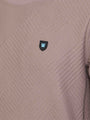 Close-up of the W-shield logo on the textured sweater – Wam Denim.