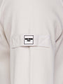 Close-up of light beige Milburn Sweater with tag. – Wam Denim.