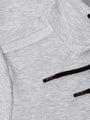 Close-up of light grey textured hoodie pocket with black drawstrings featuring Wam branding – Wam Denim.