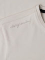 Close-up of The Fervor Light Beige Sweater shoulder embroidery reading “Art of Denim” – Wam Denim.