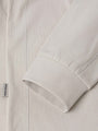 Close-up of The Fervor Light Beige Sweater sleeve cuff and side label stitching detail – Wam Denim.