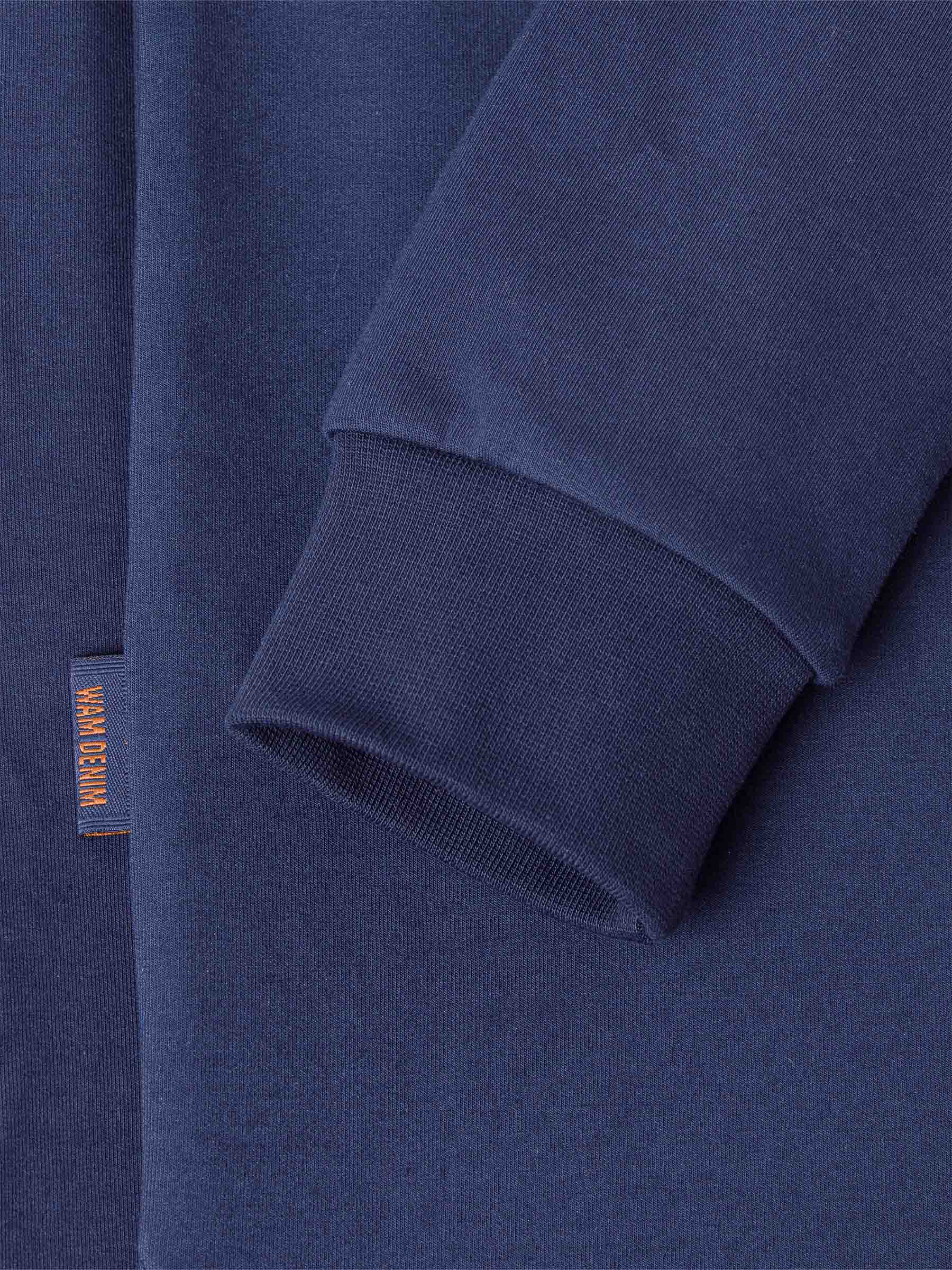 Close-up of a Navy Sweater with a brand label on a matching background