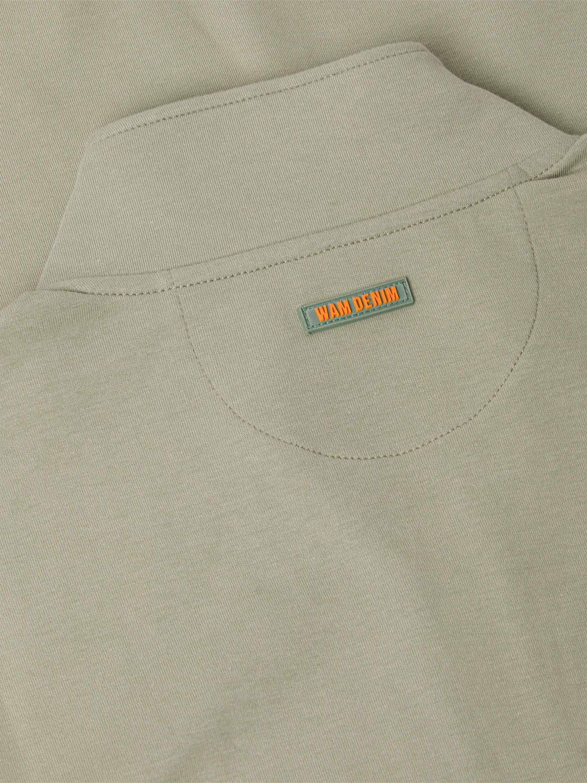 Close-up of a Light Green jacket with a 'WAM Denim' label on the chest pocket.