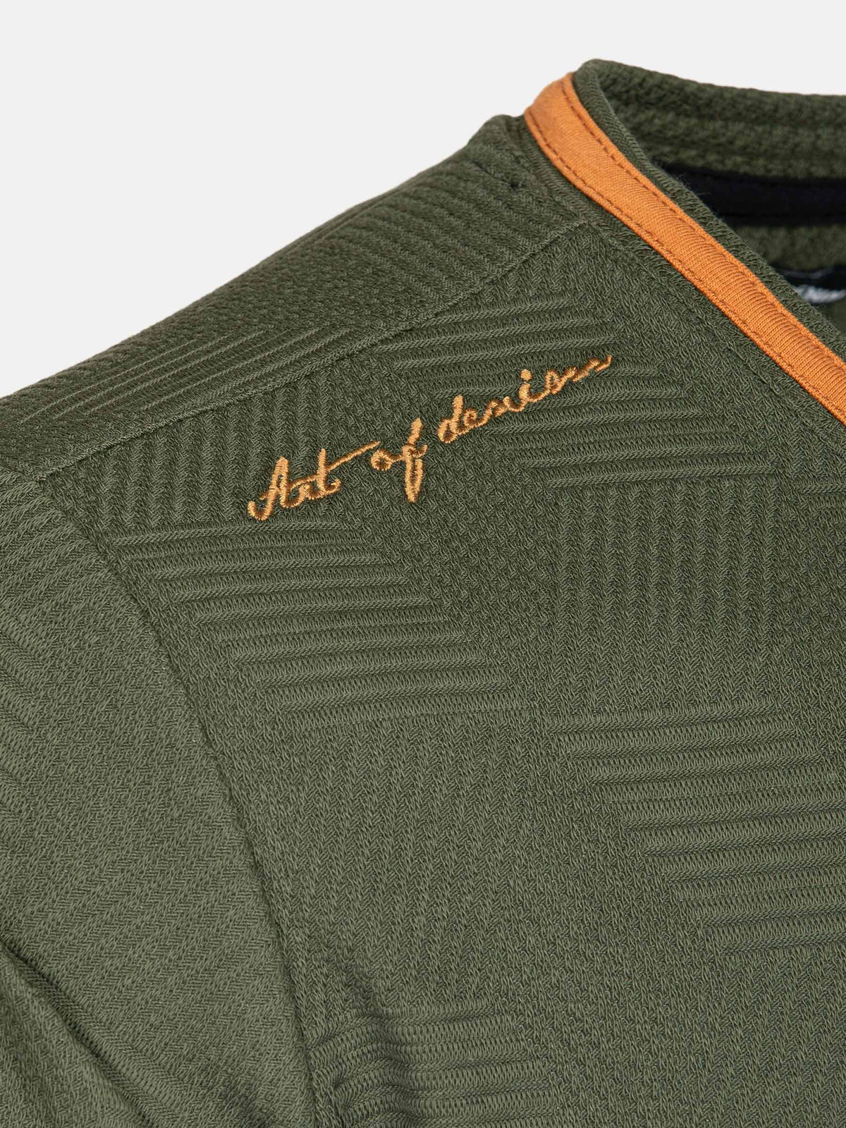 Close-up of khaki men’s T-shirt shoulder with textured fabric and embroidery detail