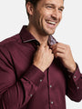 Close-up of dark red men’s shirt with patterned inner collar and button cuffs