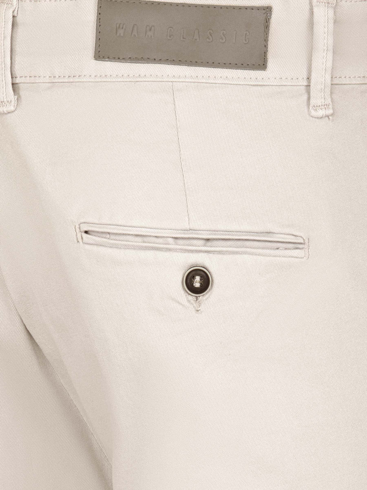 Close-up of light beige chino pants showing rear pocket, button detail, and fabric texture.