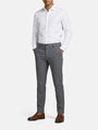 Man wearing grey slim-fit pantalon styled with a white shirt and brown dress shoes.