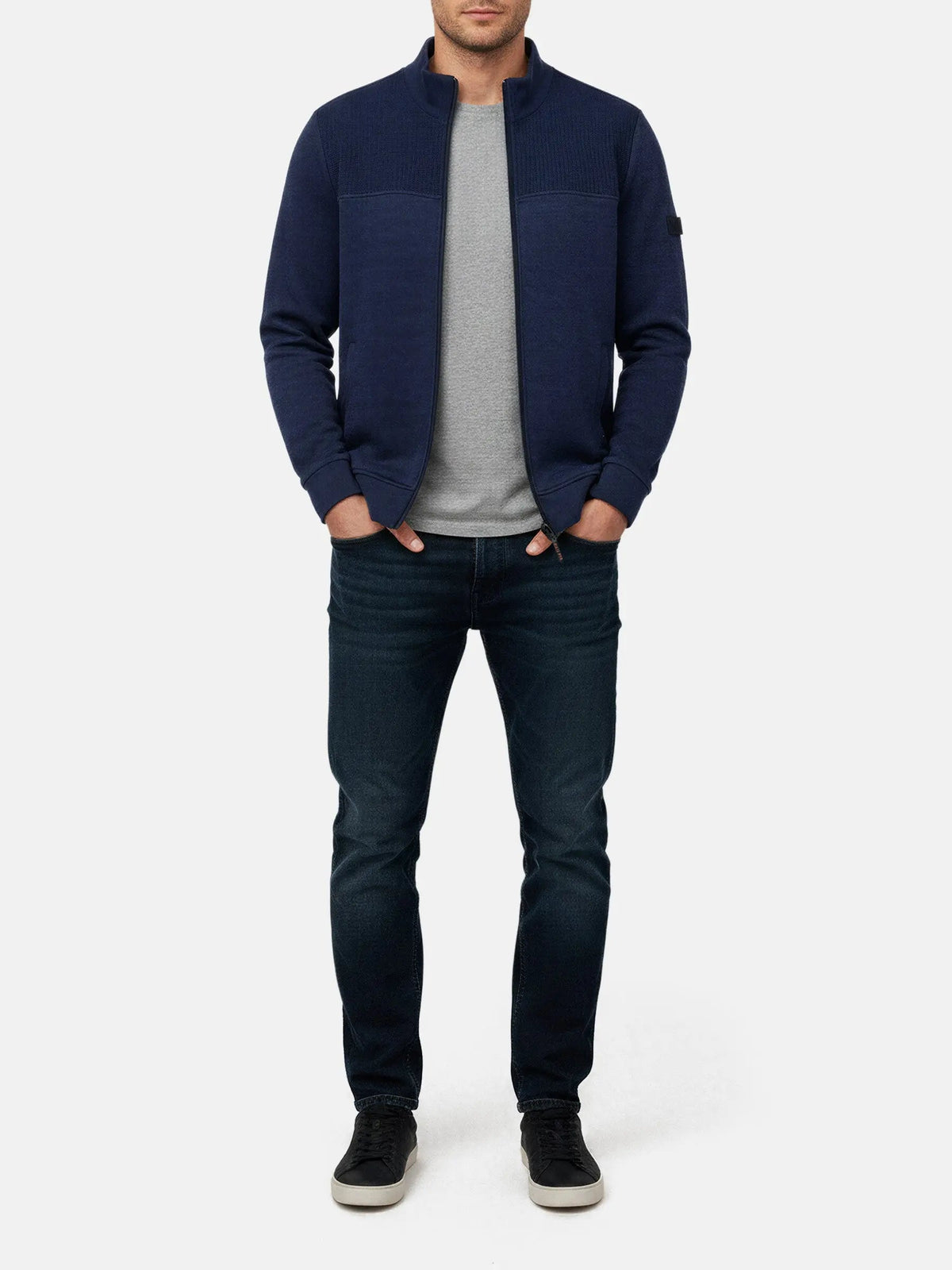 Model wearing Light Indigo full-zip men’s jacket with textured panel, styled with jeans.