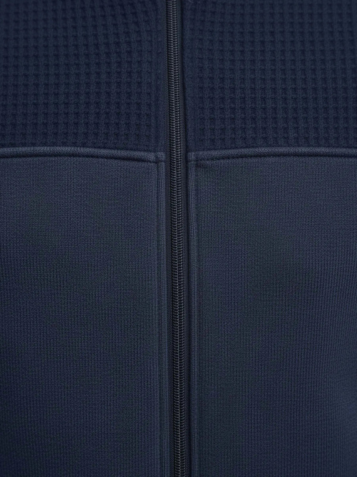 Close-up of Light Indigo jacket fabric showing textured upper panel and central zipper.