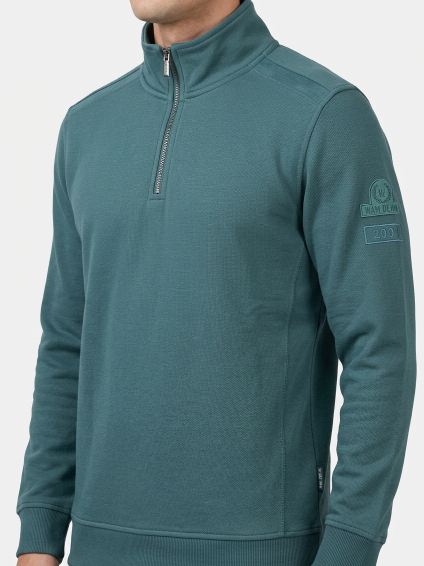 Nerik Petrol sweater quarter-zip and sleeve patch detail on model