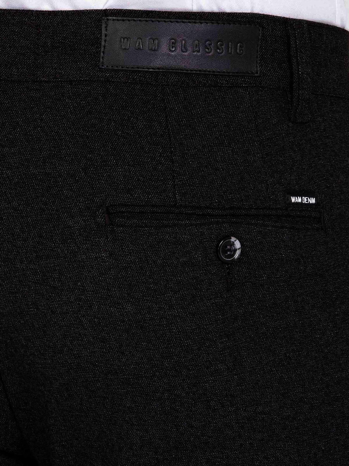 Close-up of dark grey chino trousers showing back pocket, button detail, and Wam Denim label.