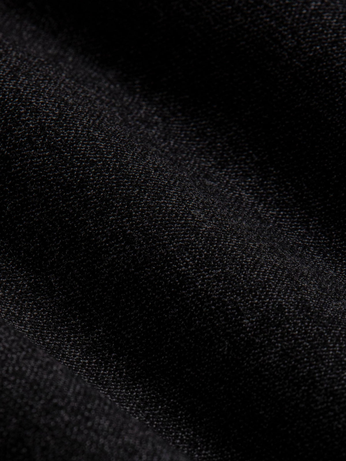 Close-up of dark grey chino fabric showing fine texture and premium woven finish.