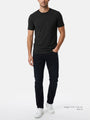 Model wearing men’s black crew neck T-shirt with slim dark jeans