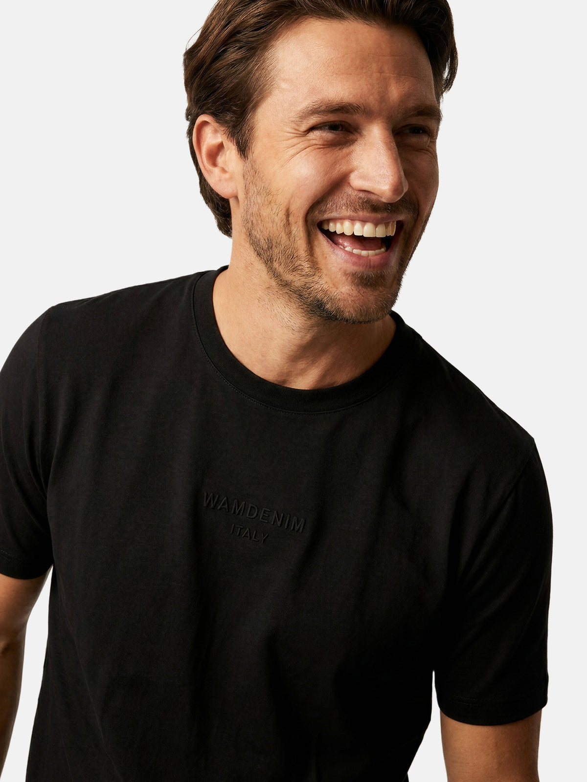 Close-up of men’s black crew neck T-shirt with subtle logo detail