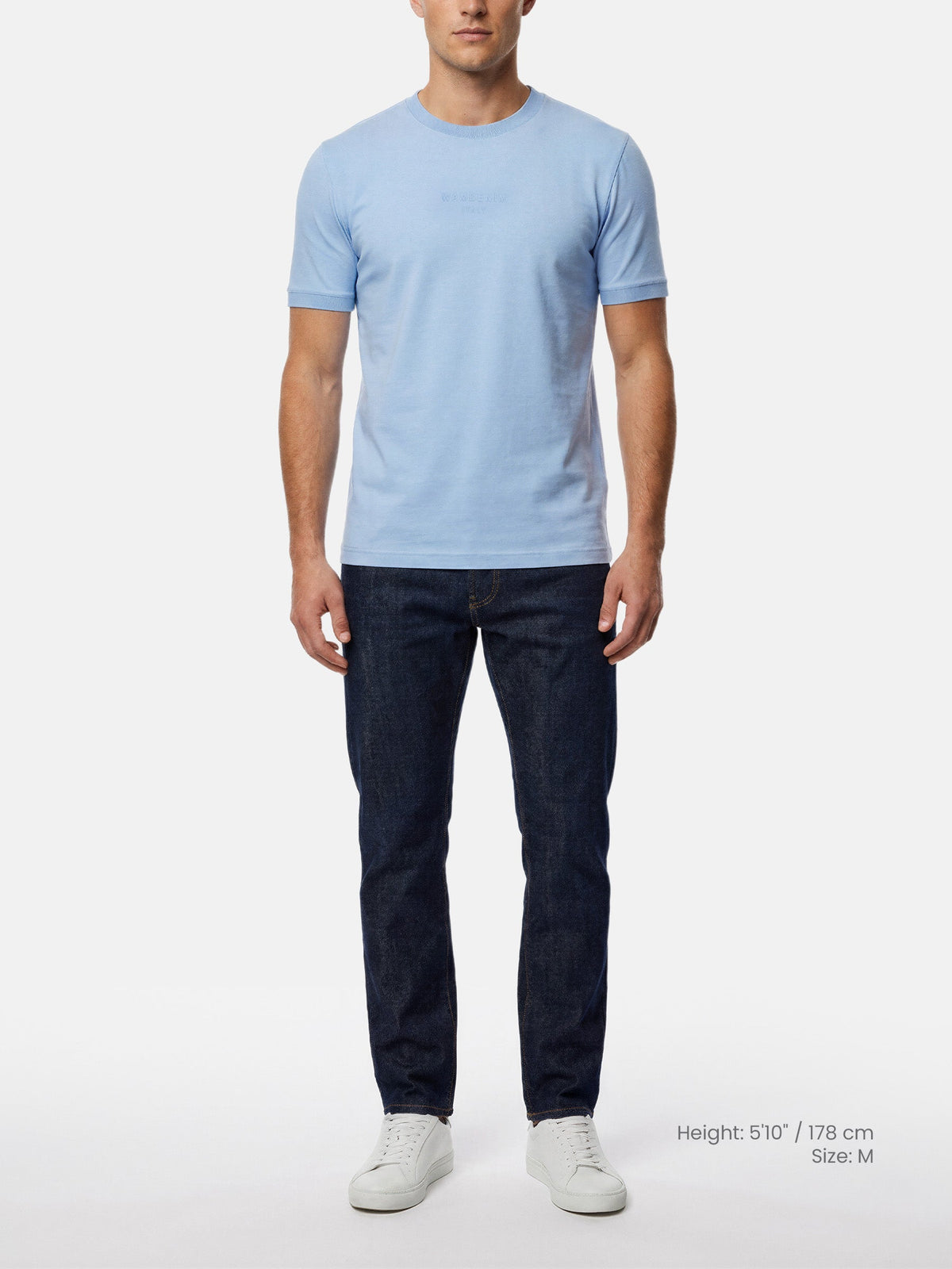Model wearing men’s light blue crew neck T-shirt with dark jeans
