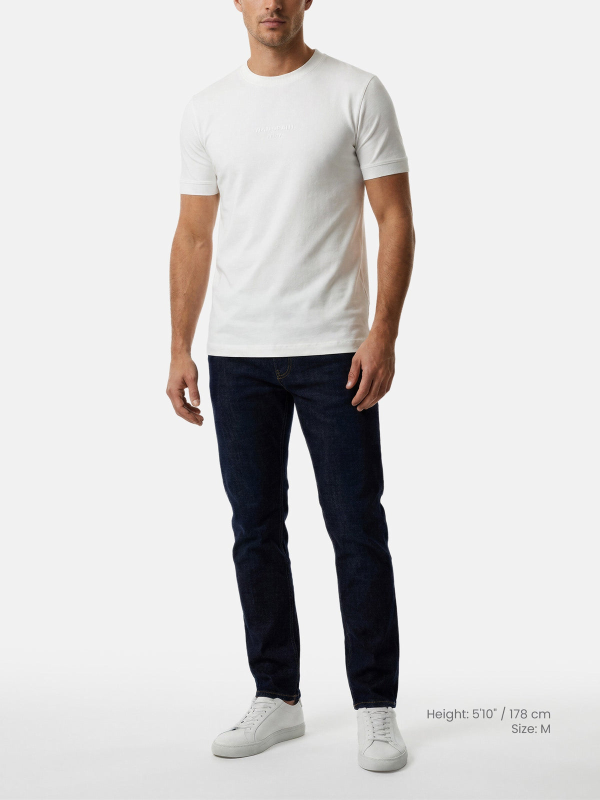 Model wearing white men’s regular fit crew neck T-shirt with jeans