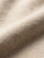 Close-up of beige pullover knit fabric showing soft, textured material detail.
