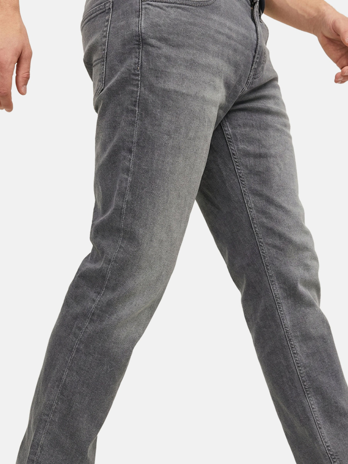 Close-up of grey denim jeans showing slim-fit leg and subtle faded texture.