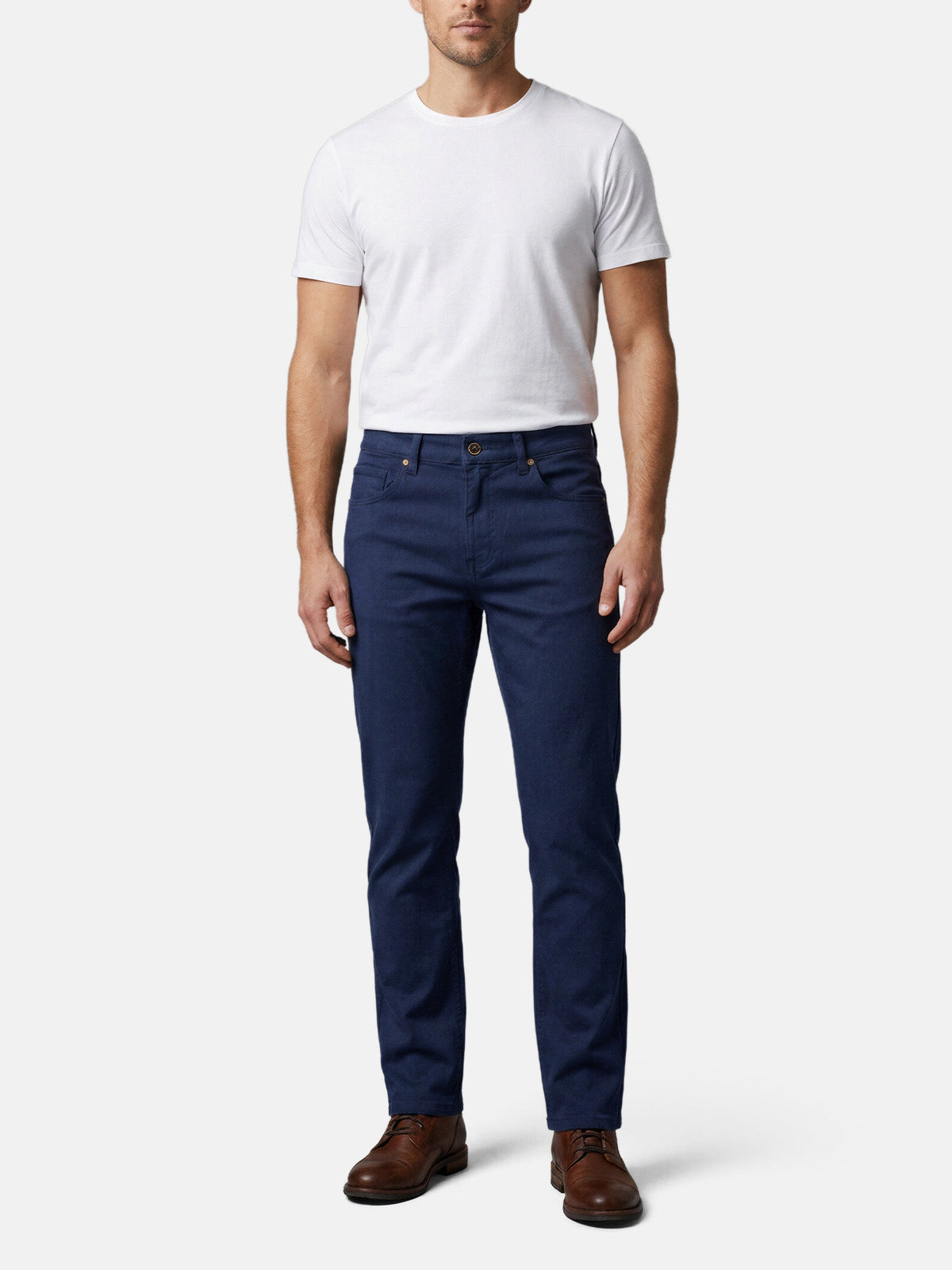 Men wearing navy slim-fit jeans styled with white T-shirt and brown leather shoes