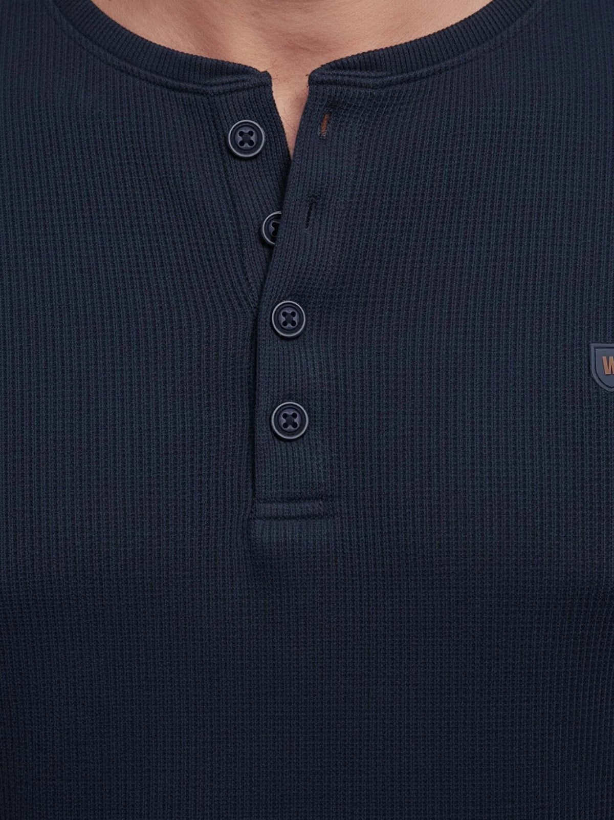 Close-up of navy Zest sweater buttons and textured knit fabric.